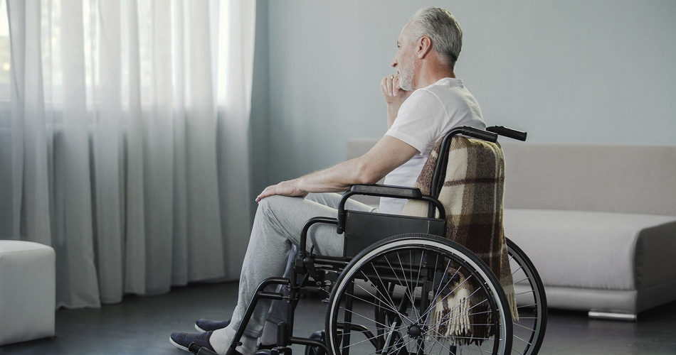 Одинокий пожилой мужчина в инвалидной коляске
